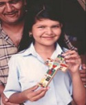 A Salvadoran girl presents her crafted cross