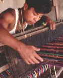 A Guatemalan young man weaves several crafts